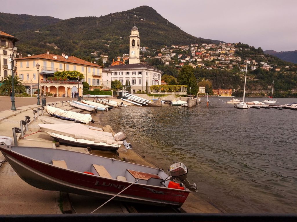 Wooden motorboat beside a lakeside village on Lake Como, Italy